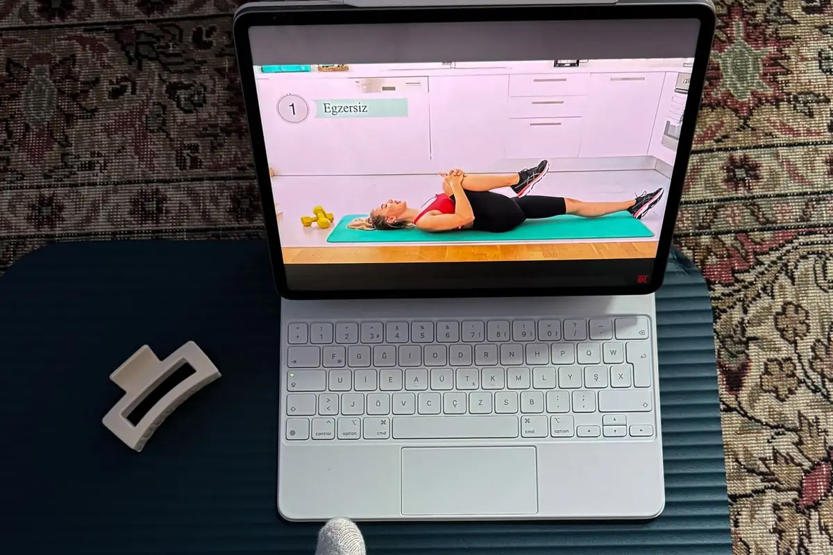 A tablet propped on an exercise mat at home, playing a guided workout session.
